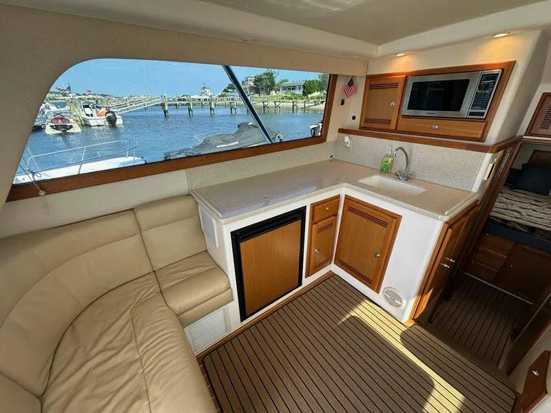 Slide: The Image of Interior of 2005 Cabo 35 Flybridge with kitchen and harbor view. - 16