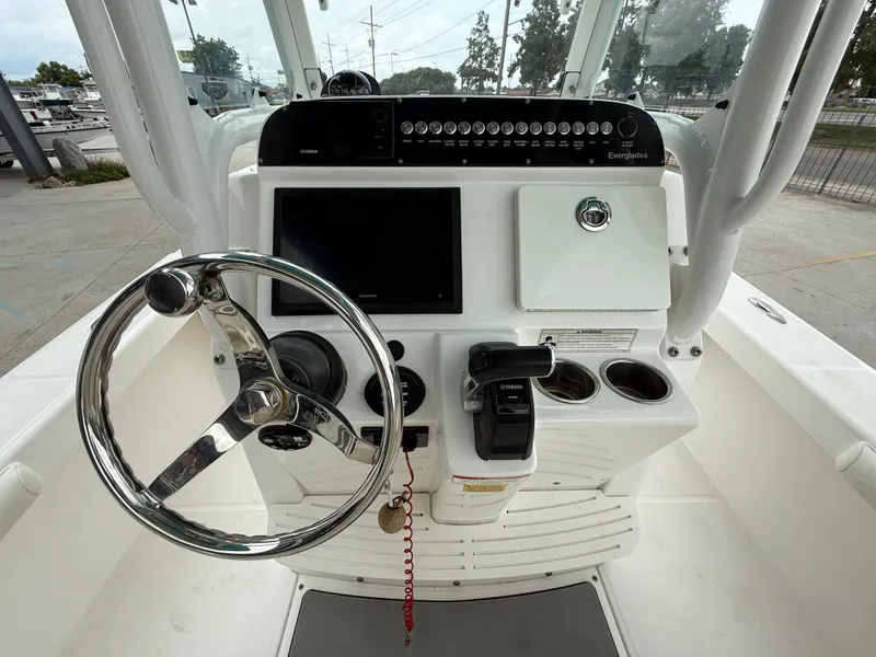 Slide: The Image of Control panel of a 2016 Everglades 243CC boat with steering wheel and navigation equipment. - 14