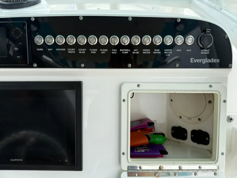 Slide: The Image of Control panel of a 2016 Everglades 243CC boat with labeled switches and storage compartment. - 15