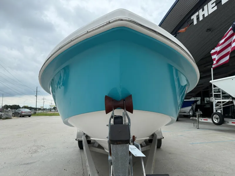 Slide: The Image of 2016 Everglades 243CC boat on trailer, blue hull, overcast sky, American flag nearby. - 3
