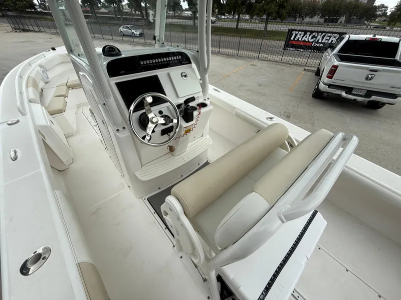 Slide: The Image of 2016 Everglades 243CC boat interior with steering wheel and seating, parked near a white truck. - 9