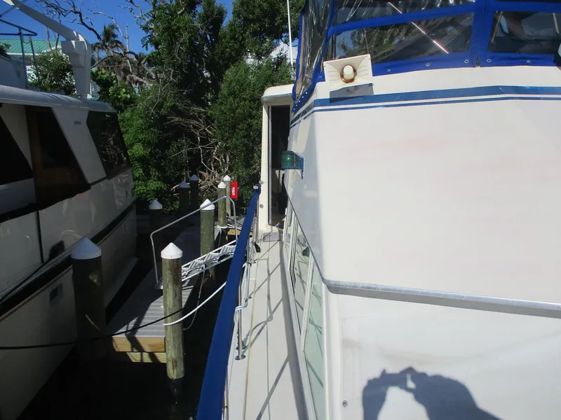 Slide: The Image of 1986 Hatteras 43 Double Cabin yacht docked beside another boat. - 11