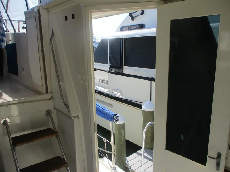 Slide: The Image of 1986 Hatteras 43 Double Cabin interior view with open door to dock. - 14