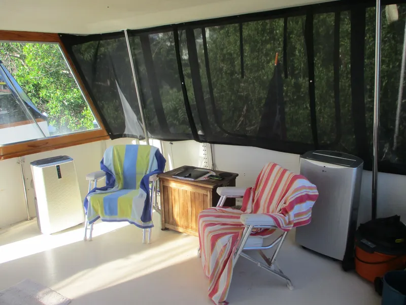 Slide: The Image of 1986 Hatteras 43 Double Cabin interior with chairs, striped towels, and appliances. - 16