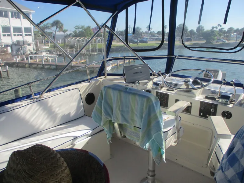 Slide: The Image of 1986 Hatteras 43 Double Cabin helm with Garmin navigation, overlooking marina and waterfront. - 22