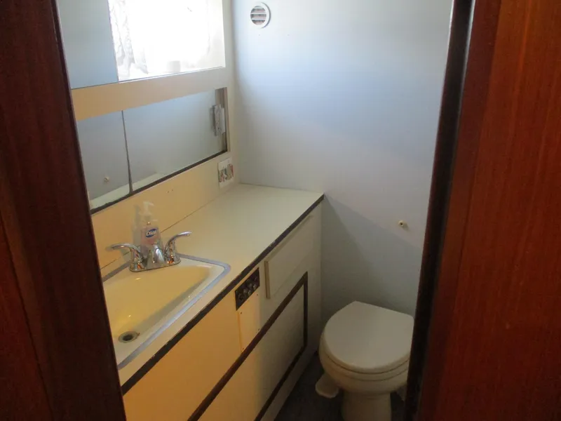 Slide: The Image of 1986 Hatteras 43 Double Cabin bathroom with sink, mirror, and toilet. - 24