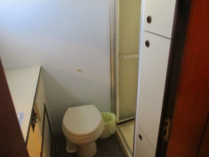 Slide: The Image of Bathroom interior of 1986 Hatteras 43 Double Cabin yacht, featuring toilet and shower. - 25