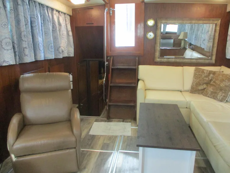 Slide: The Image of Interior of 1986 Hatteras 43 Double Cabin with beige seating and wooden accents. - 41