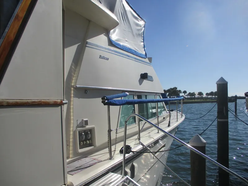 Slide: The Image of 1986 Hatteras 43 Double Cabin yacht docked by the water on a sunny day. - 5