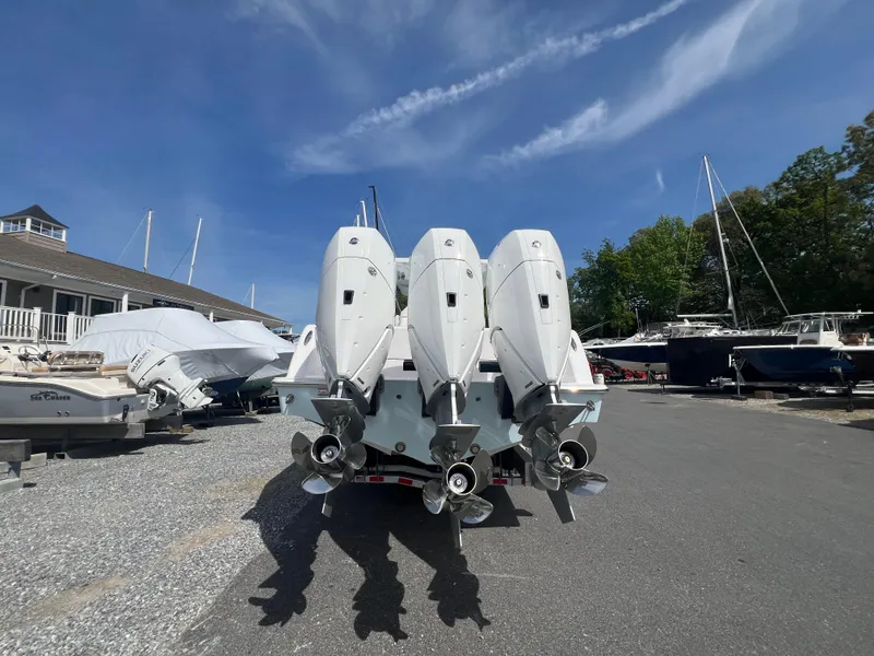 Slide: The Image of 2024 Invincible 39 Open Fisherman with triple outboard engines in a boatyard. - 2