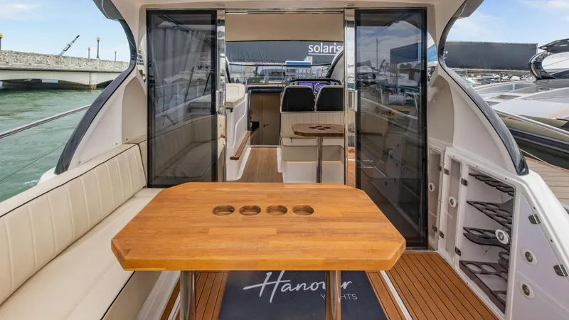 Slide: The Image of Luxurious Hanover 415 yacht interior, featuring elegant seating and wooden table, 2025 model. - 16