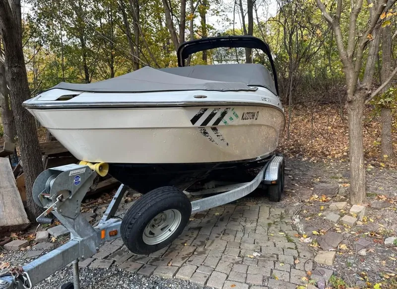 Slide: The Image of 2016 Yamaha AR240 boat on trailer in wooded area. - 2