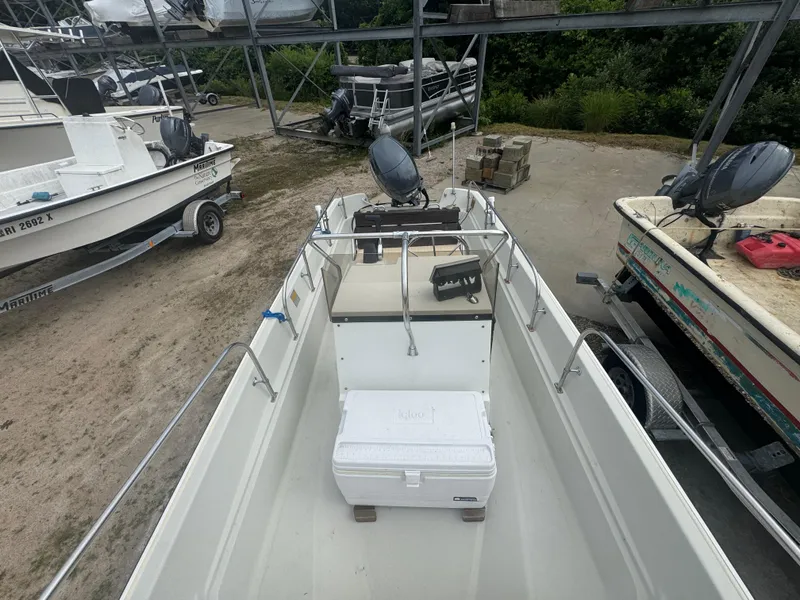 Slide: The Image of 1984 Boston Whaler 170 Montauk boat on trailer, with cooler and console, in storage area. - 11