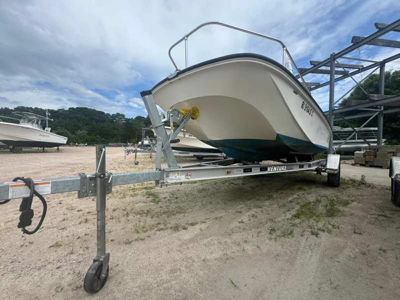 Slide: The Image of 1984 Boston Whaler 170 Montauk on trailer, parked outdoors under cloudy sky. - 20