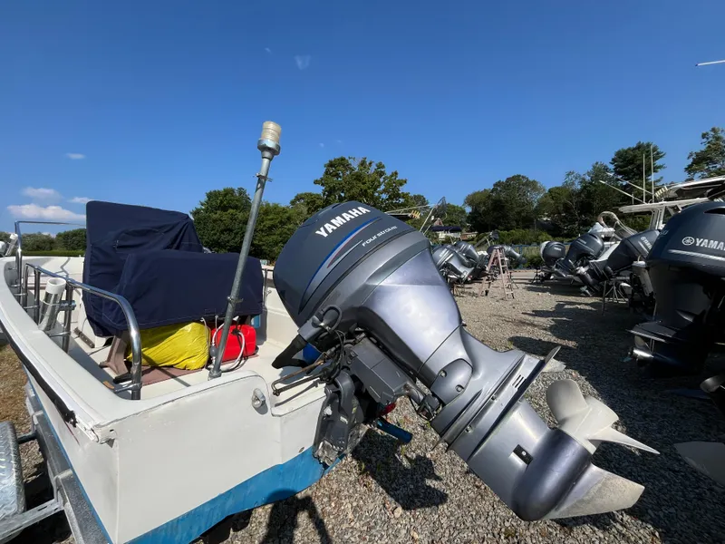 Slide: The Image of 1984 Boston Whaler 170 Montauk with Yamaha outboard motor in a boatyard. - 22