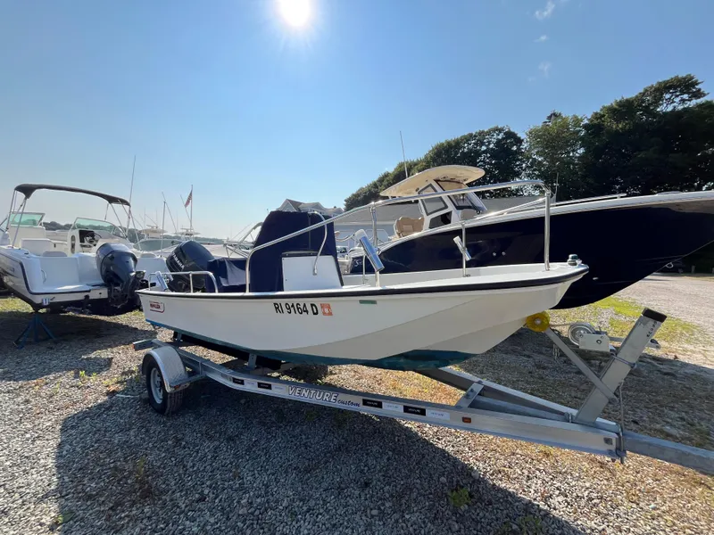 Slide: The Image of 1984 Boston Whaler 170 Montauk boat on trailer under sunny sky. - 26