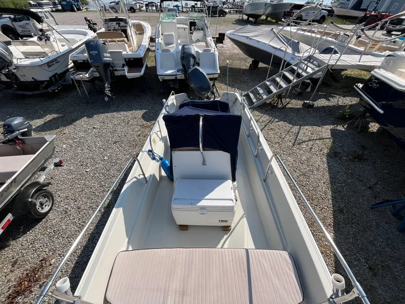 Slide: The Image of 1984 Boston Whaler 170 Montauk boat displayed in a marina with other vessels. - 28