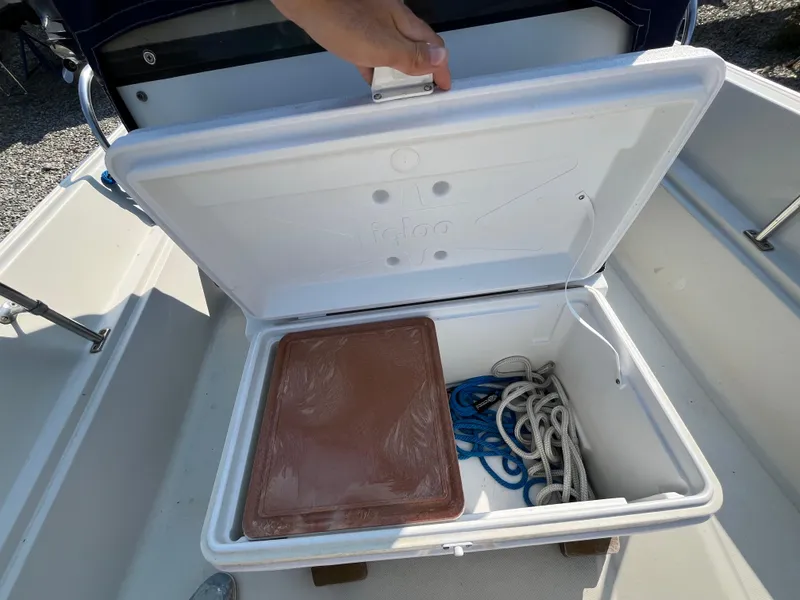 Slide: The Image of Open cooler on 1984 Boston Whaler 170 Montauk boat, containing ropes and a brown tray. - 29
