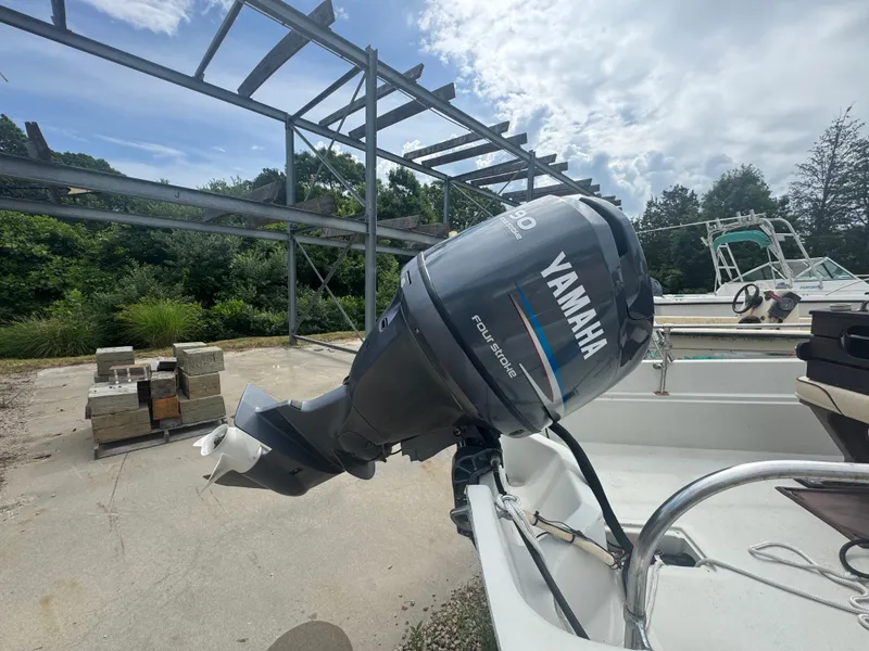 Slide: The Image of 1984 Boston Whaler 170 Montauk with Yamaha outboard motor in a boatyard setting. - 4