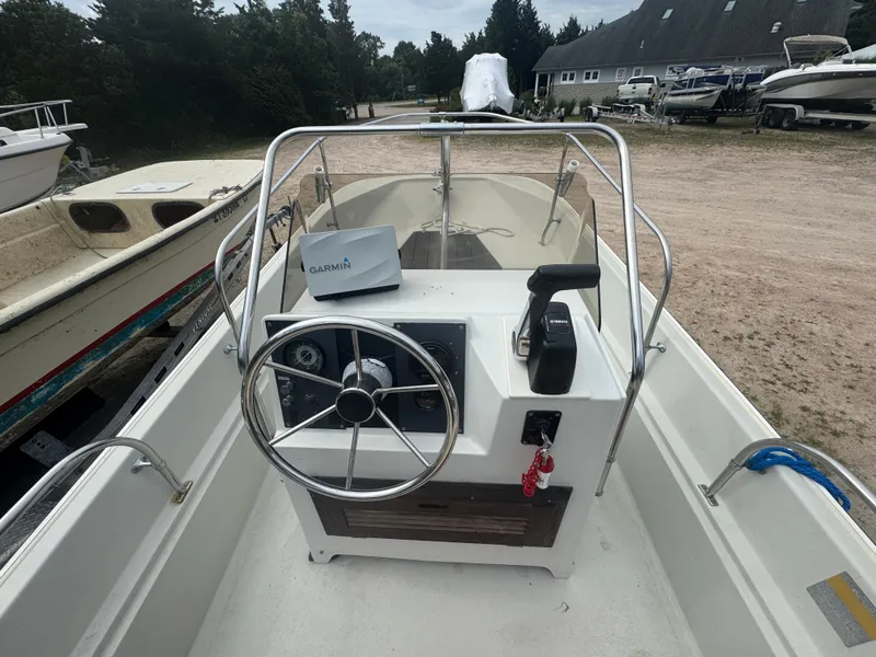 Slide: The Image of 1984 Boston Whaler 170 Montauk boat interior with steering wheel and Garmin device. - 7