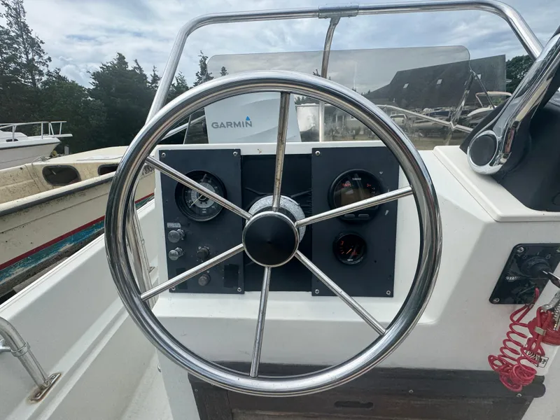 Slide: The Image of 1984 Boston Whaler 170 Montauk steering wheel and dashboard with Garmin equipment. - 8