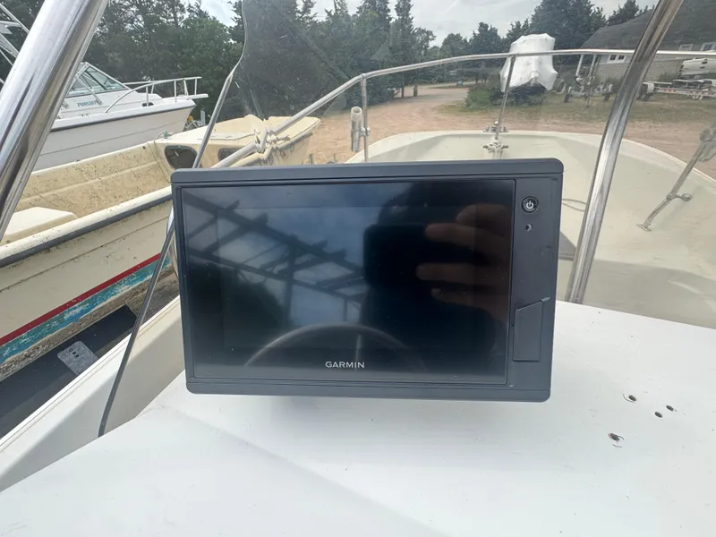 Slide: The Image of Garmin device on 1984 Boston Whaler 170 Montauk boat dashboard, outdoor setting. - 9