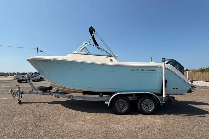Slide: The Image of 2017 Cobia 220 Dual Console boat on trailer under clear blue sky. - 1