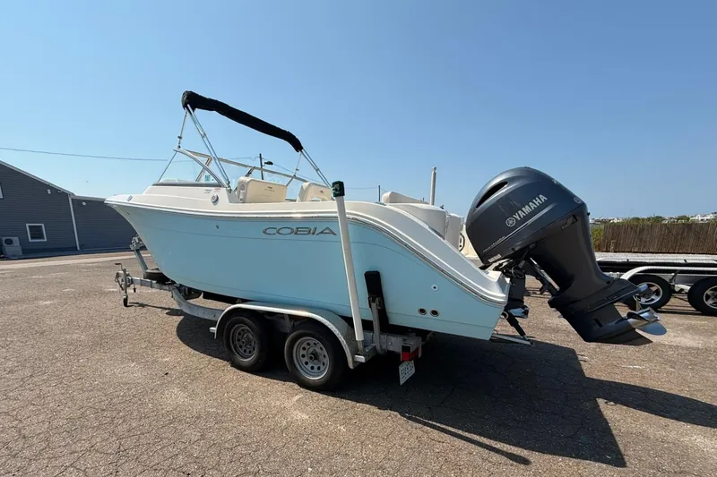 Slide: The Image of 2017 Cobia 220 Dual Console boat on trailer with Yamaha outboard motor. - 2