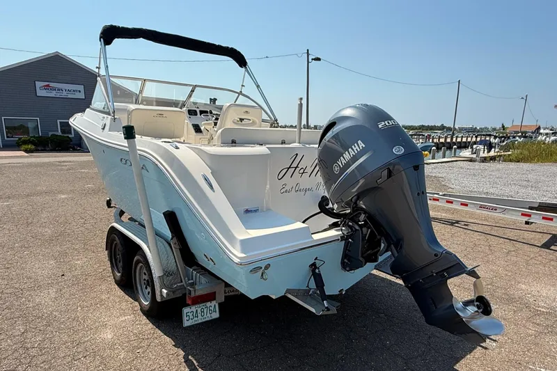 Slide: The Image of 2017 Cobia 220 Dual Console boat with Yamaha engine on trailer, parked near marina. - 3