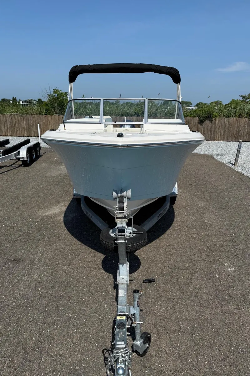 Slide: The Image of 2017 Cobia 220 Dual Console boat on trailer, parked outdoors on a sunny day. - 6