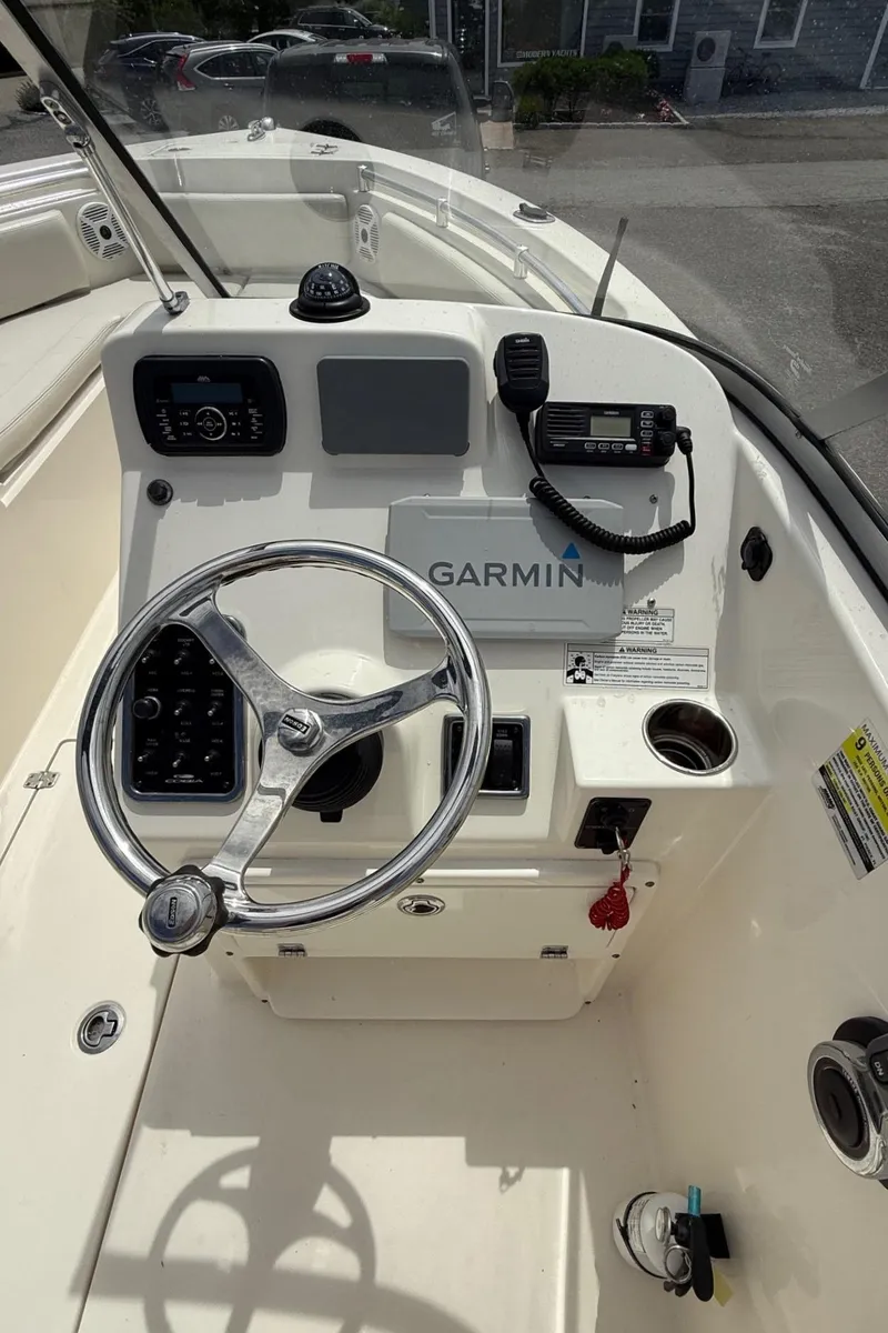 Slide: The Image of 2017 Cobia 220 Dual Console boat dashboard with Garmin navigation system and steering wheel. - 9