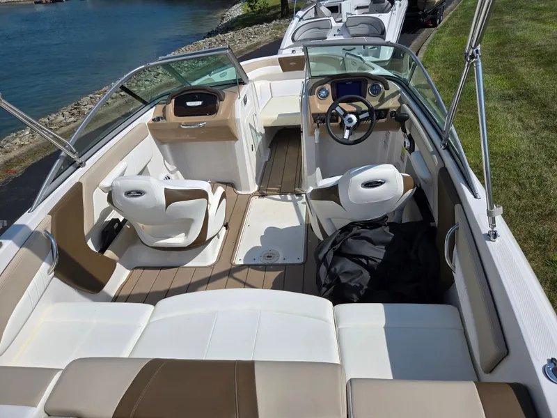 Slide: The Image of 2022 Chaparral 21 SSi boat interior with seating and steering wheel by the water. - 10