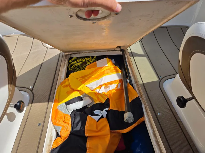 Slide: The Image of Storage compartment in 2022 Chaparral 21 SSi boat with life jackets and equipment. - 12
