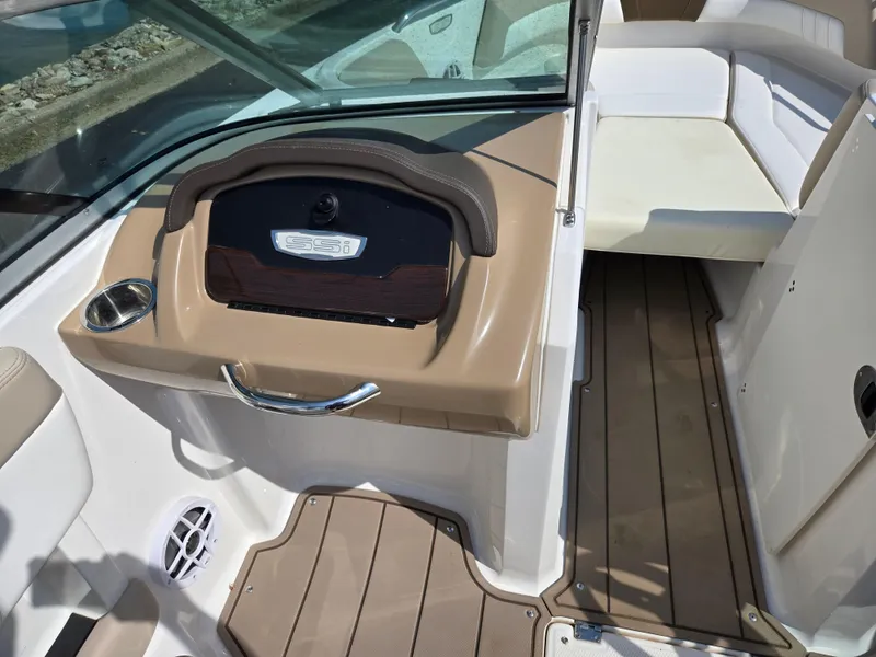 Slide: The Image of 2022 Chaparral 21 SSi boat interior with tan and white seating and wood accents. - 13