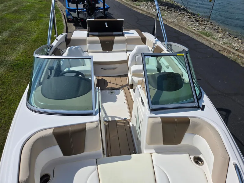 Slide: The Image of 2022 Chaparral 21 SSi boat interior with beige seating and open windshield. - 21