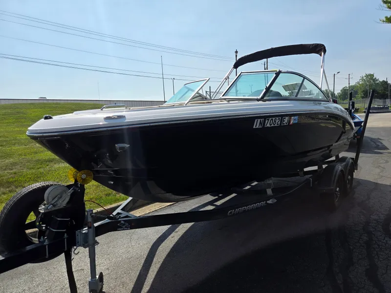 Slide: The Image of 2022 Chaparral 21 SSi boat on trailer, parked outdoors under clear sky. - 5