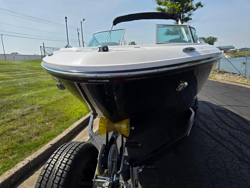 Slide: The Image of 2022 Chaparral 21 SSi boat on trailer, parked on a sunny day near a grassy area. - 6