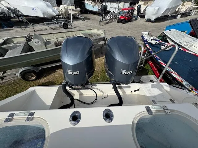 Slide: The Image of 2015 Cobia 296 Center Console with twin 300 horsepower engines in a boatyard. - 16