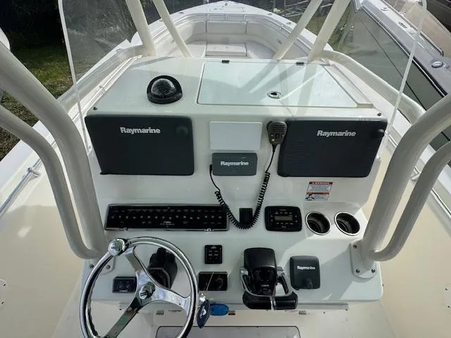 Slide: The Image of 2015 Cobia 296 Center Console boat dashboard with Raymarine electronics and steering wheel. - 20