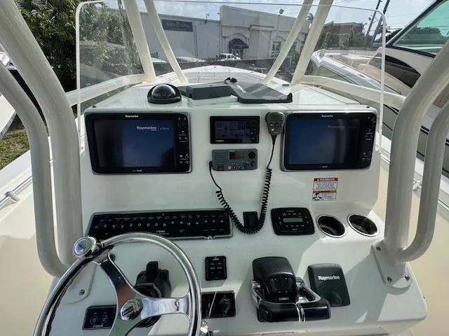 Slide: The Image of 2015 Cobia 296 Center Console helm with dual Raymarine displays and steering wheel. - 21
