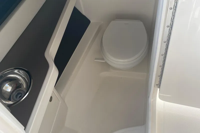 Slide: The Image of 2015 Cobia 296 Center Console boat interior with toilet and sink. - 32