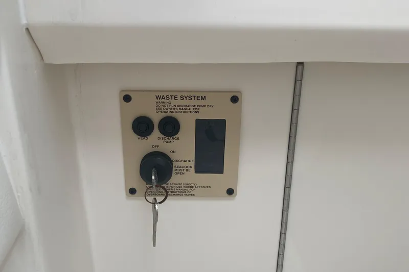 Slide: The Image of 2015 Cobia 296 Center Console waste system control panel with key. - 35