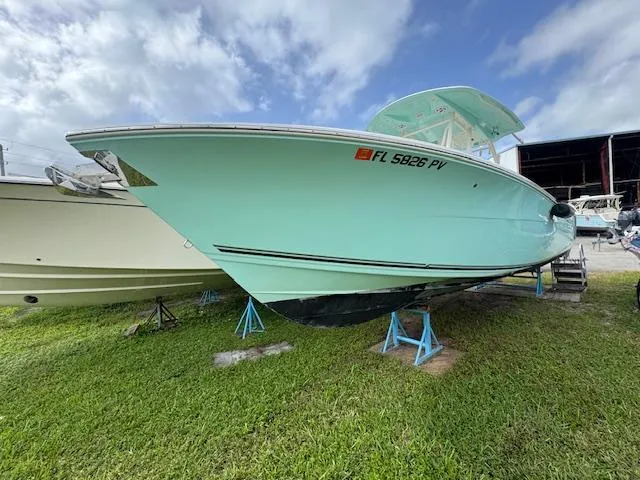 Slide: The Image of 2015 Cobia 296 Center Console boat on stands, displayed outdoors. - 4