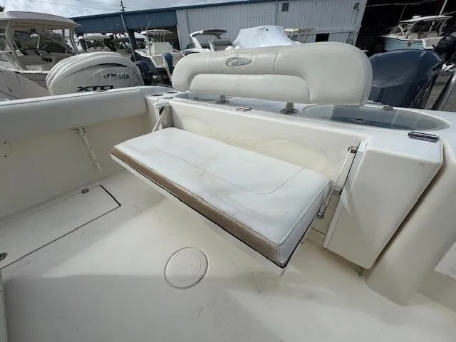 Slide: The Image of 2015 Cobia 296 Center Console boat with foldable rear seat in a marina setting. - 42