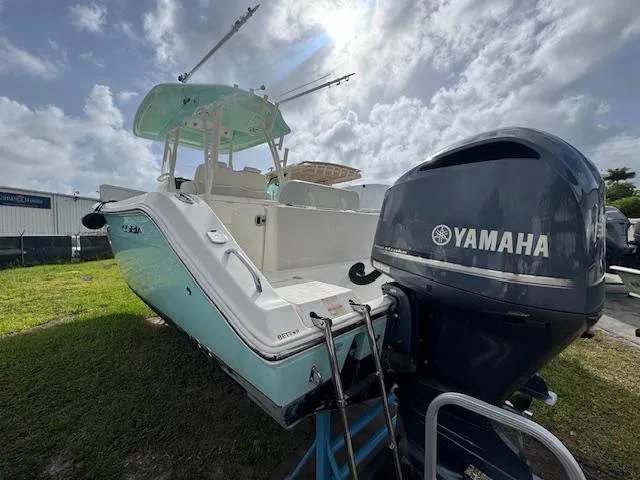 Slide: The Image of 2015 Cobia 296 Center Console boat with Yamaha engine, parked on grass under cloudy sky. - 5