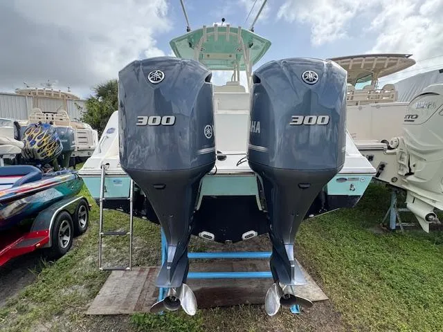 Slide: The Image of 2015 Cobia 296 Center Console with twin Yamaha 300 engines, docked on grass. - 8