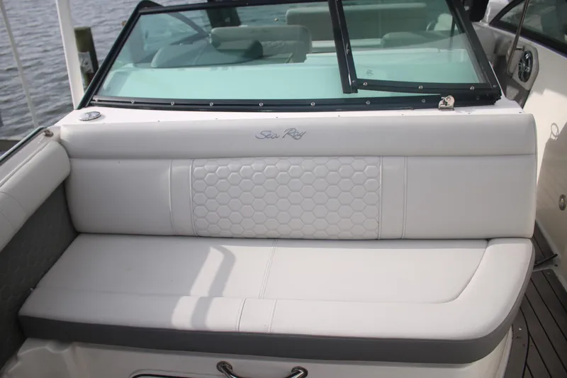 Slide: The Image of 2022 Sea Ray 250 SDX-OB boat interior with white cushioned seating and windshield. - 13