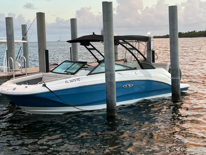 Slide: The Image of 2022 Sea Ray 250 SDX-OB boat docked on calm water at sunset. - 14