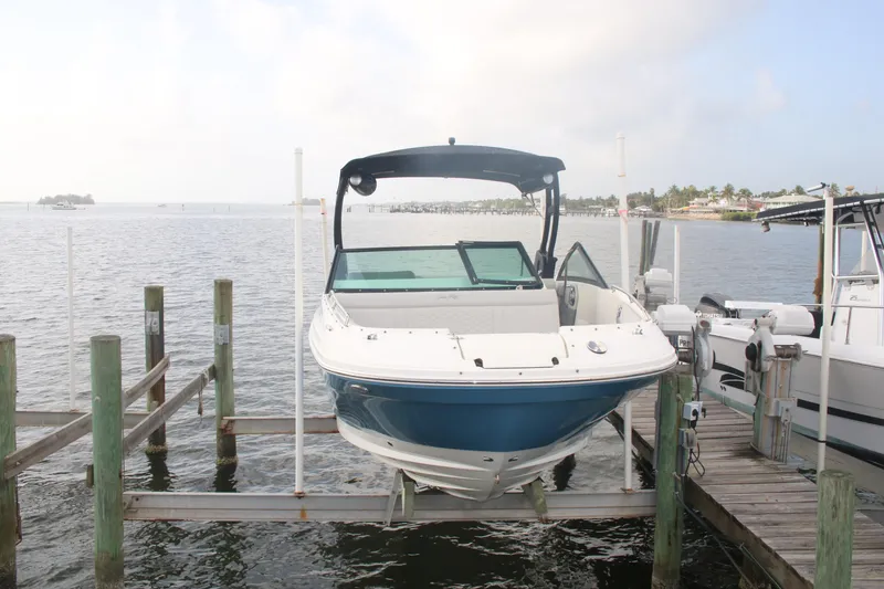 Slide: The Image of 2022 Sea Ray 250 SDX-OB boat docked on a lift by the water. - 4