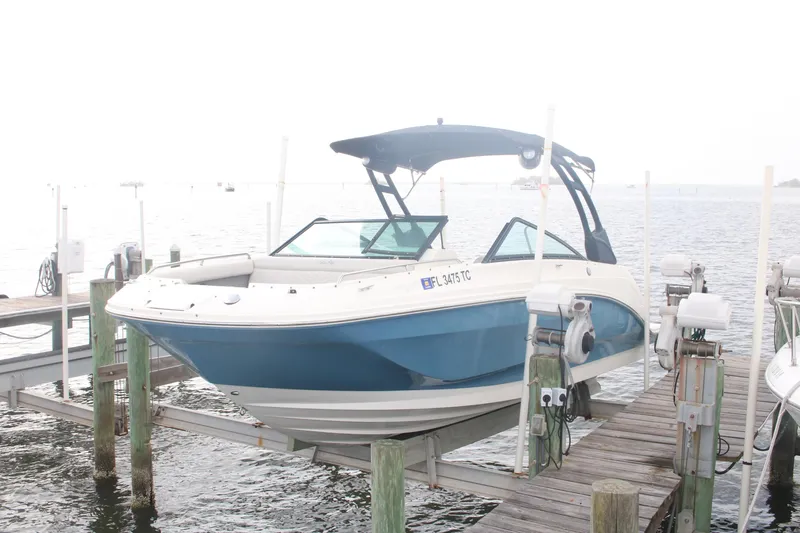 Slide: The Image of 2022 Sea Ray 250 SDX-OB boat docked on a lift by the water. - 5